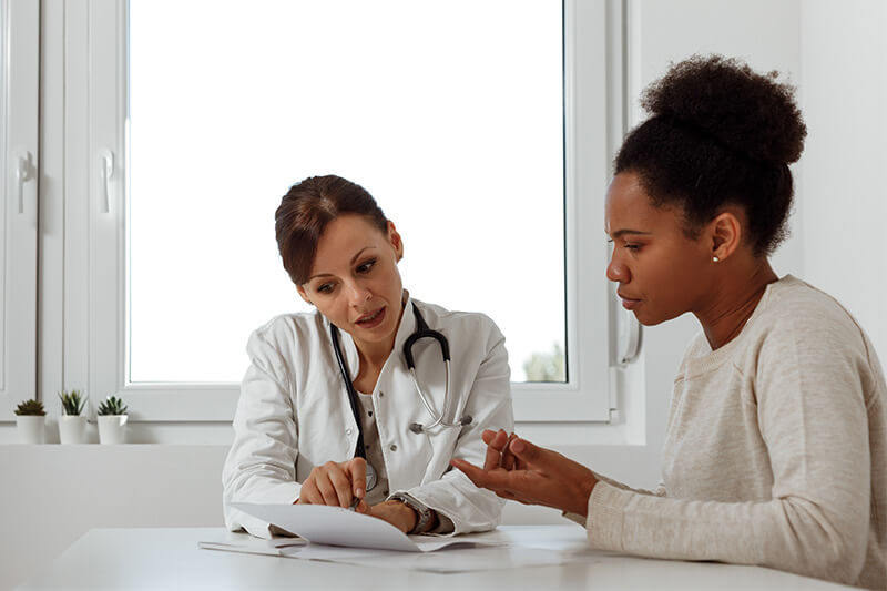 A woman discussing side effects with her doctor